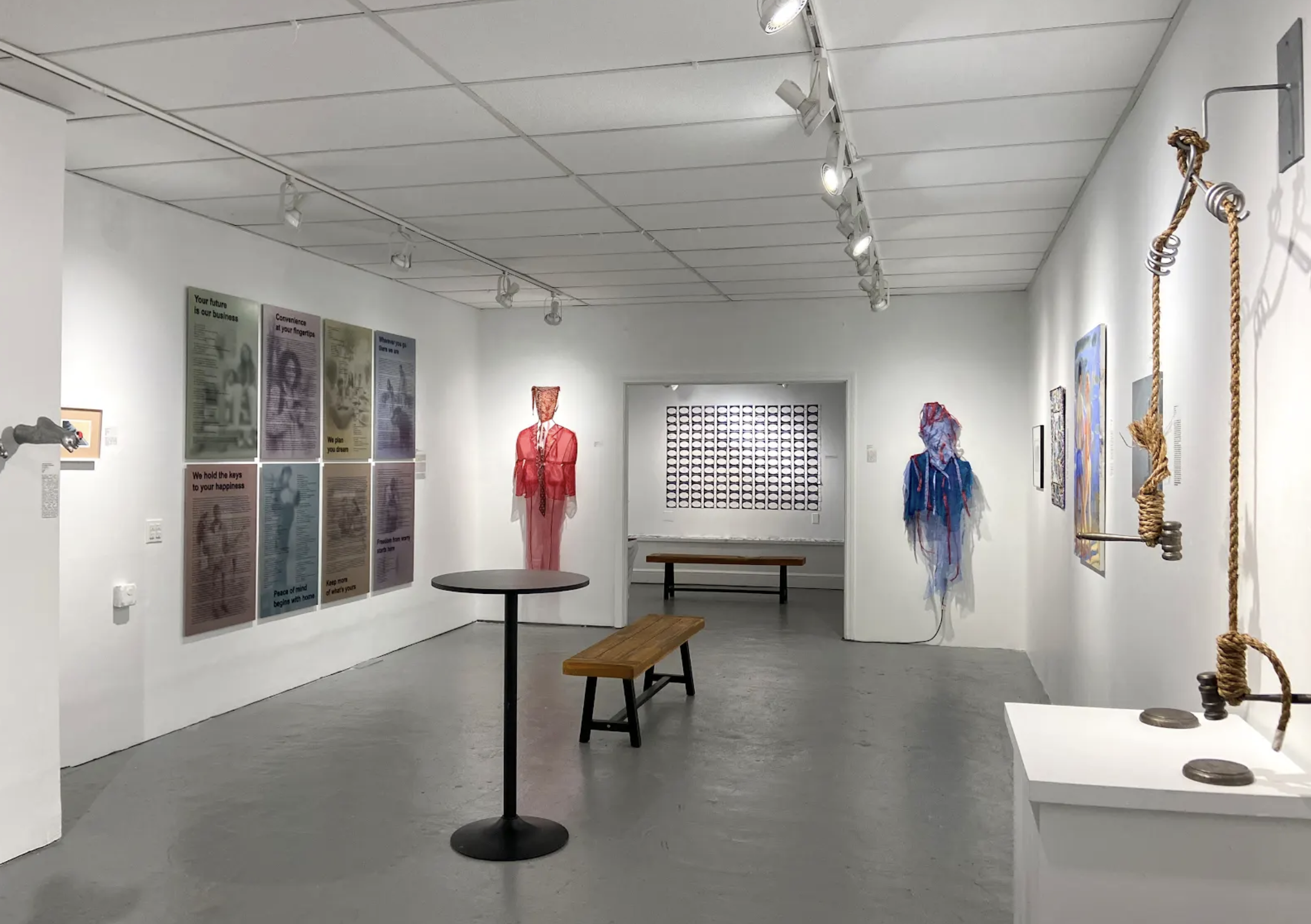 8 Panel Wall by Valerie Mendoza displayed Gallery space containing two costumed figures, prints, and a sculpture made with rope