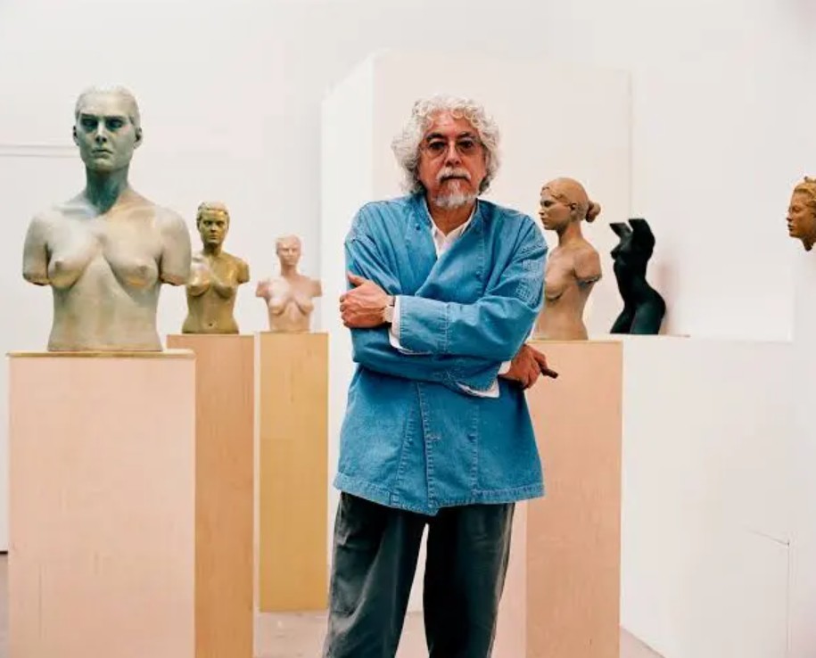 Sculptor Robert Graham standing next to one of his monumental bronze figurative sculptures.