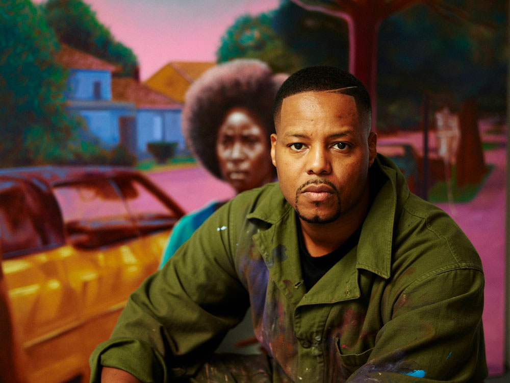 MacArthur Fellow Titus Kaphar standing in his painting studio with cut and physically deconstructed historical canvases.