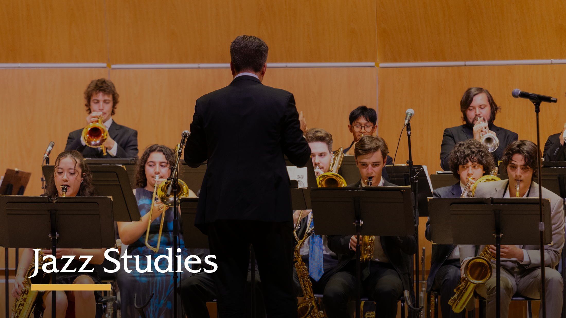 Students performing with jazz instruments on stage.