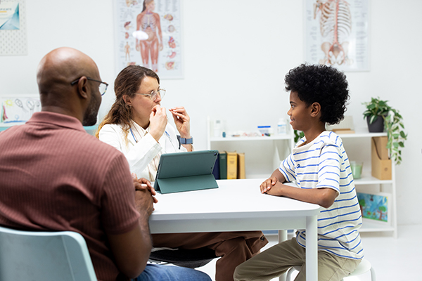 Speech pathologist with child and his parent