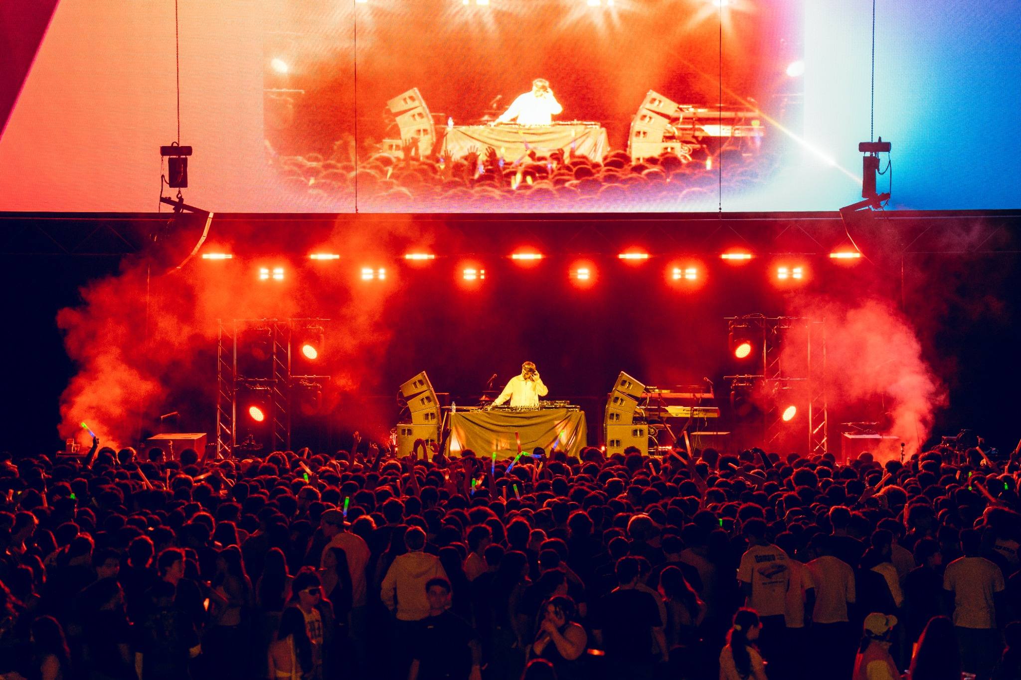 Concert in the event center with bright lights and students dancing.